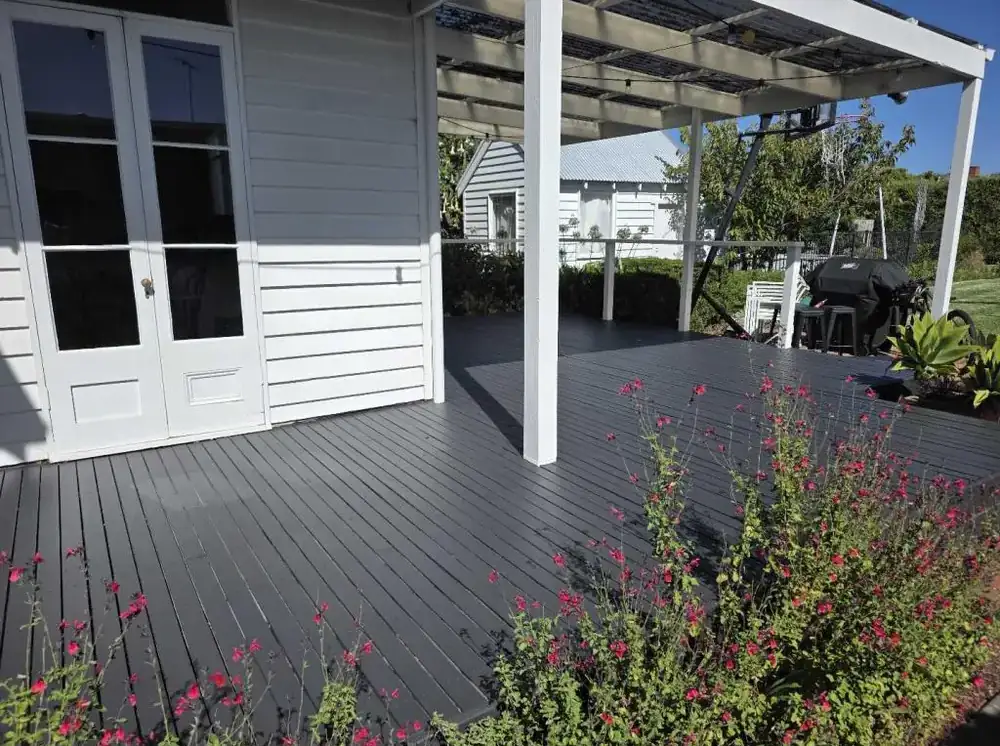 Charcoal-stained timber deck beside a white weatherboard home
