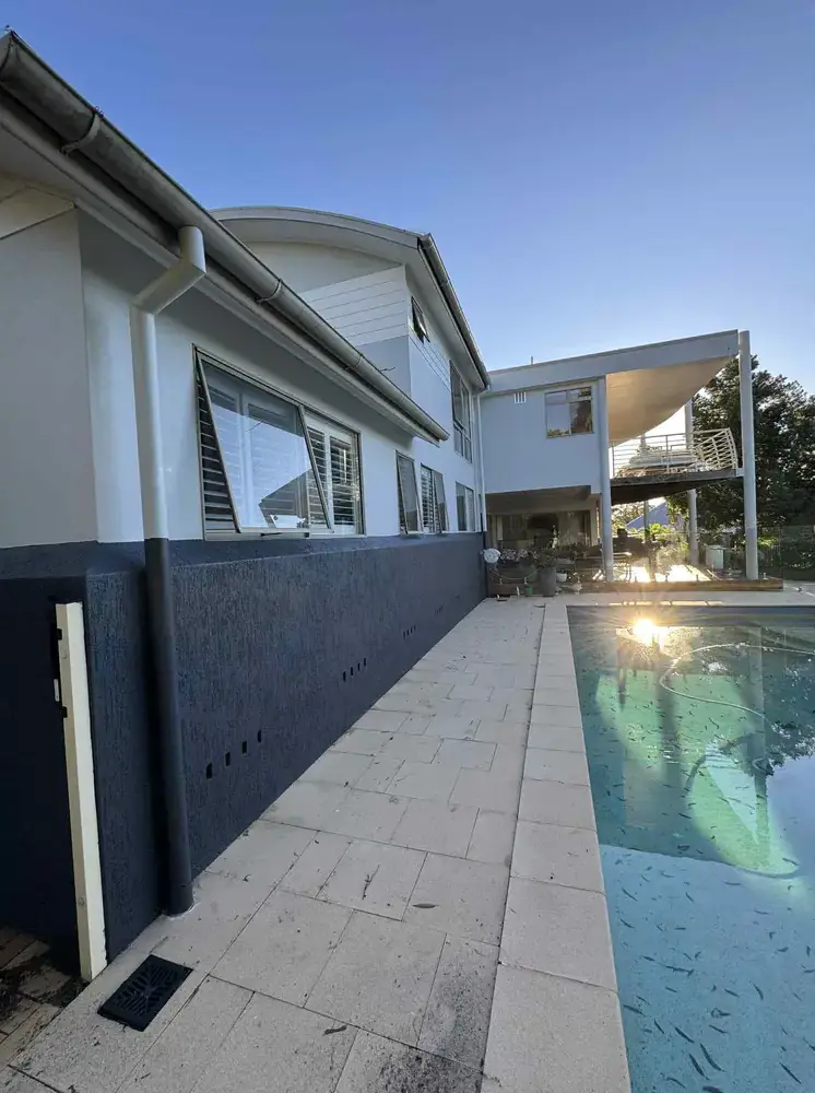 Modern home exterior and poolside path after painting