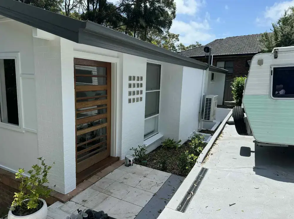 White rendered home exterior with timber entry feature
