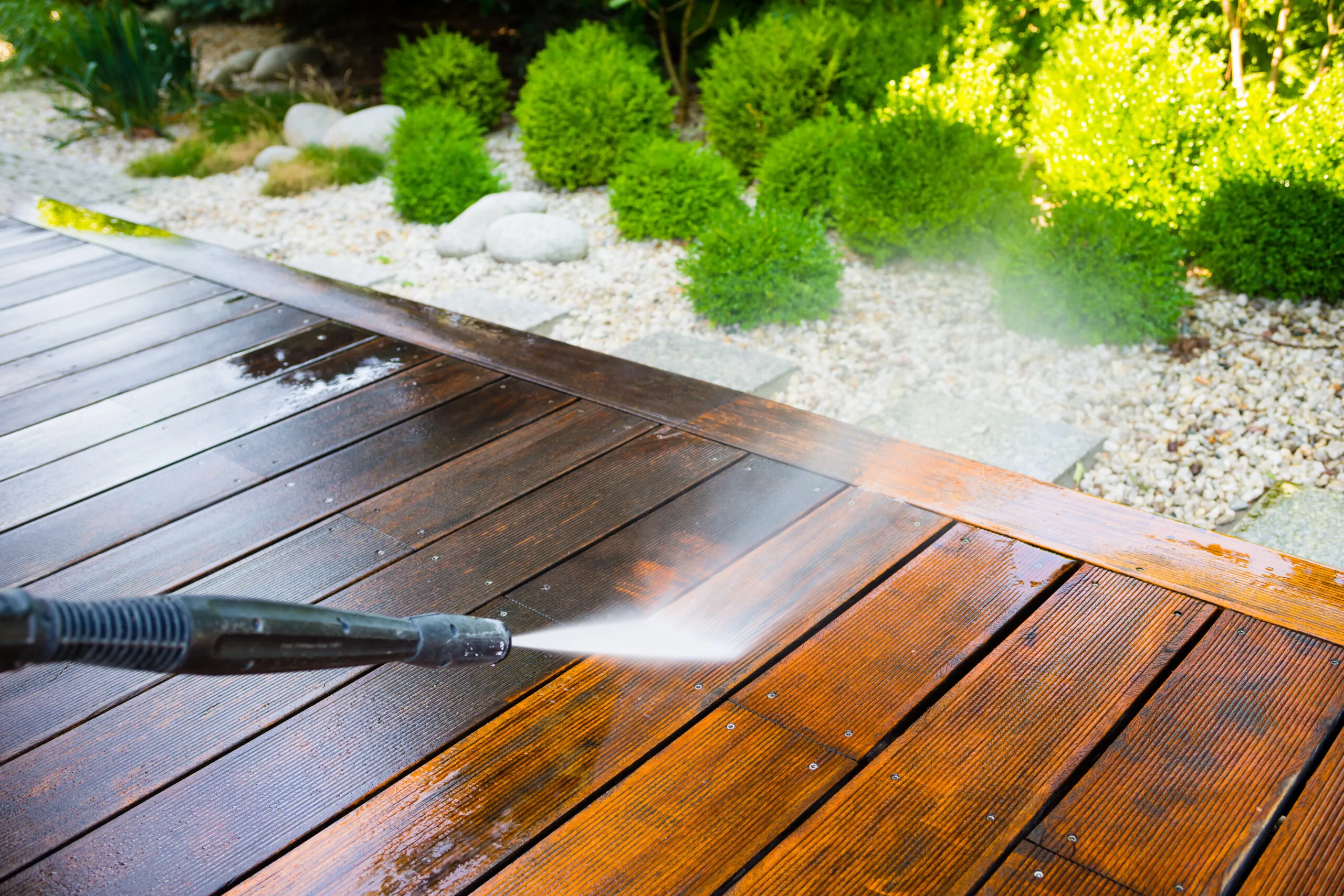 High-pressure water jet cleaning a timber deck